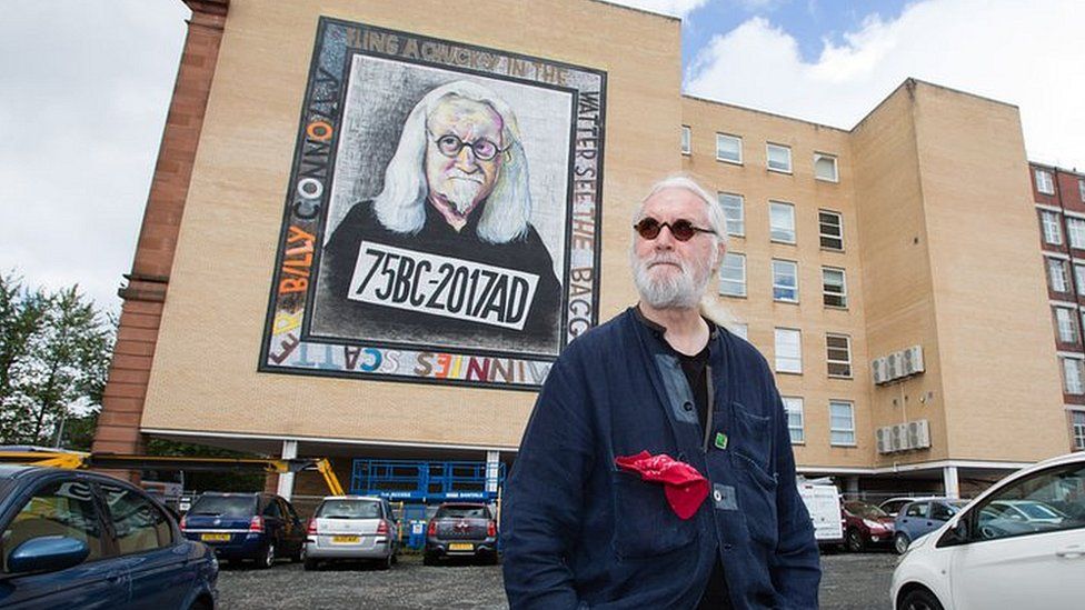 Billy Connolly next to one of his murals