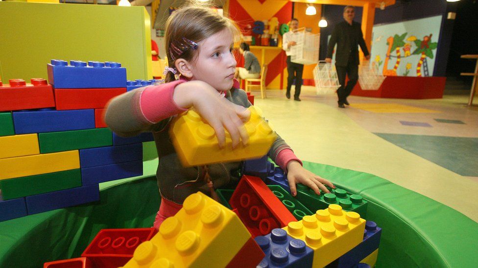 A young girl playing with Lego