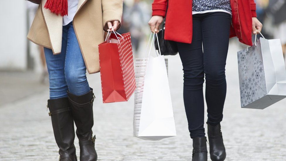 Two women walking with shopping bags
