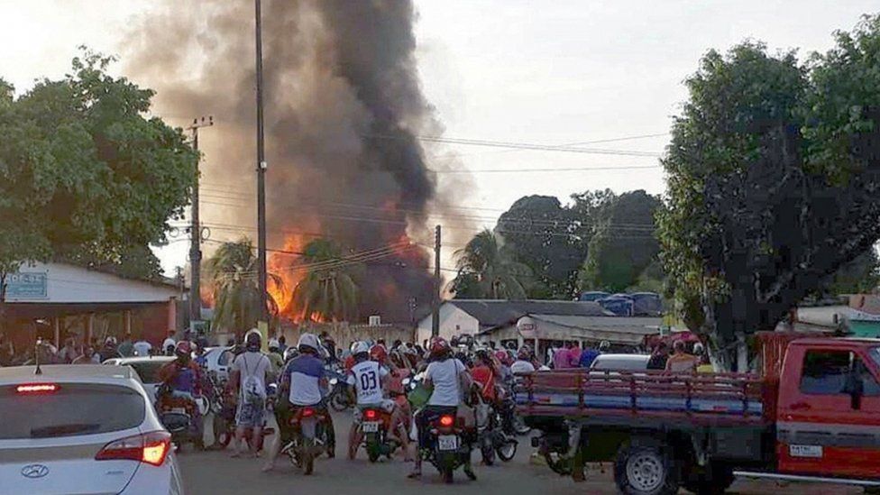 Motorcyclists watching a fire at the headquarters on the National Institute of Colony and Agrarian Reform (INCRA) in the municipality of Humaita
