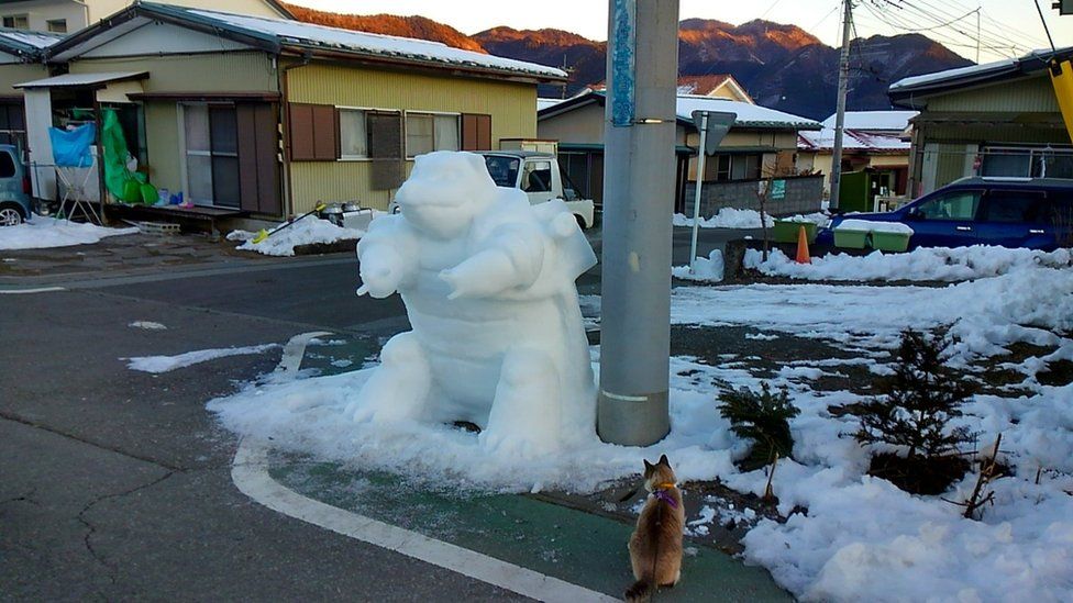 Instagram user kazu.sae's snow creation - a Pokemon Kamex character in a car park.