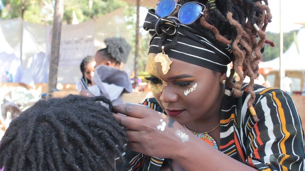 Mokeira Oyaro does body art on a man at the Africa Nouveau Festival on Saturday in Nairobi, Kenya.
