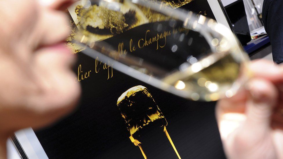 A woman sips from a champagne glass