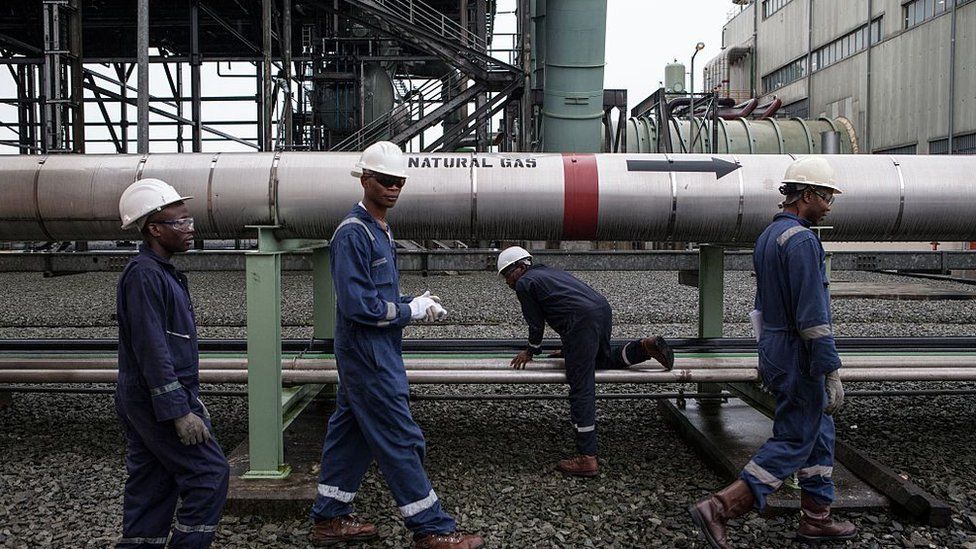 Workers next to a natural gas pipeline in Port Harcourt