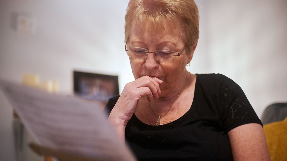 Stock image of a pensioner looking at a letter