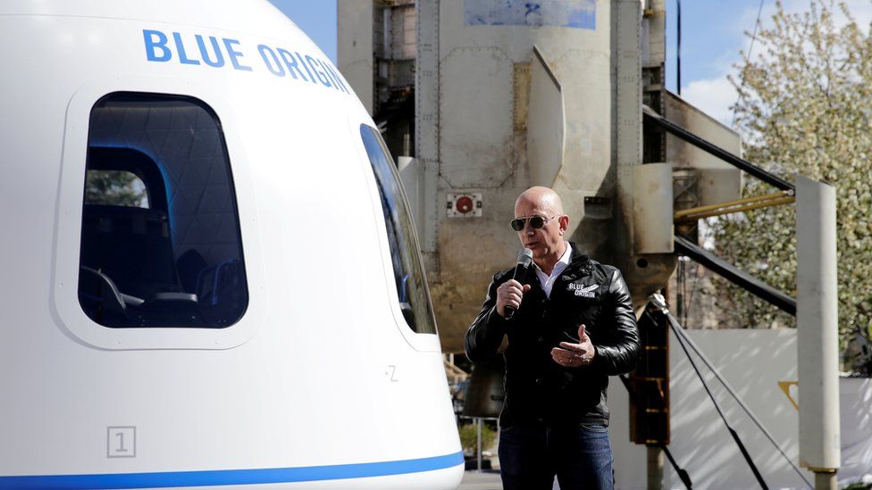 Jeff Bezos addresses the media next to the New Shepard launch vehicle. File photo