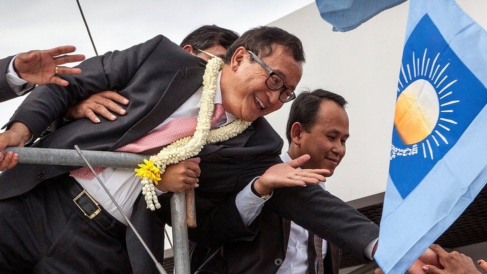 Cambodia National Rescue Party President Sam Rainsy greets supporters at Phnom Penh International Airport after arriving in Cambodia on July 19, 2014 in Phnom Penh, Cambodia