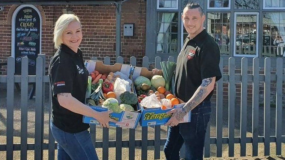 Trina Lake and Bradley Richards with boxes of fruit and vegetables