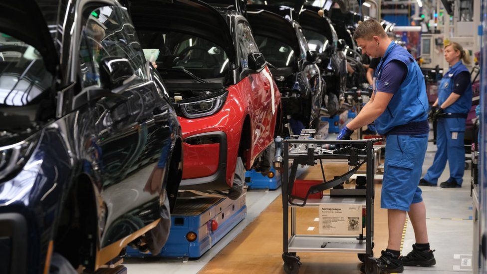 BMW workers assemble electric cars at an assembly line in Leipzig