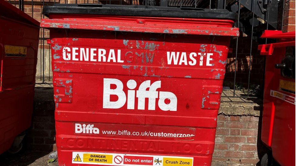 A red Biffa commercial bin with lid popped open