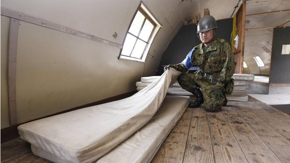 A member of the Self-Defense Force shows the mattress which Yamato Tanooka, a 7-year-old Japanese boy who went missing nearly a week ago, was using inside a building in a military drill area in Shikabe town, on Japan"s northernmost main island of Hokkaido Friday, June 3, 2016.