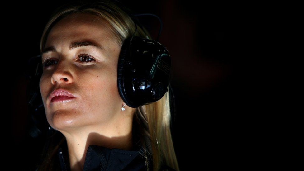 A close-up of Carmen Jorda wearing large headphones and looking determined.