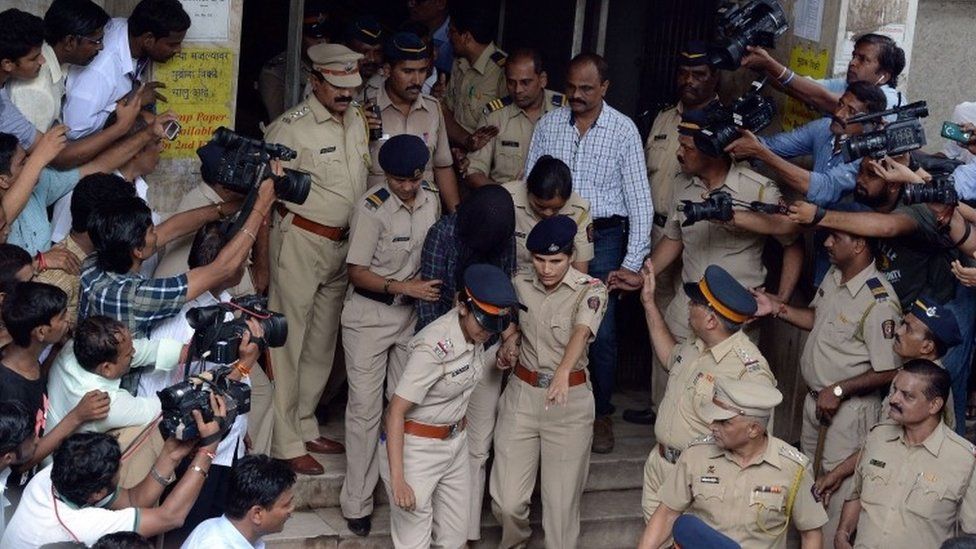 Индийская полиция окружена СМИ, когда они сопровождают бывшего руководителя СМИ Индрани Мукерджа (C) из городского суда в Мумбаи 31 августа 2015 г.