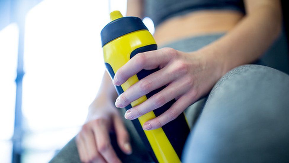 woman holding a water bottle