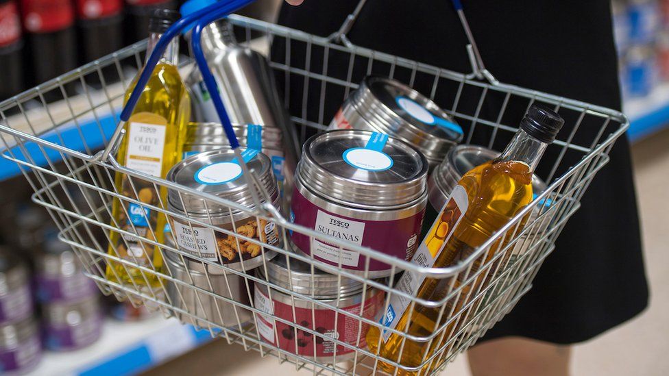 A shopping basket containing Tesco products in reusable packaging