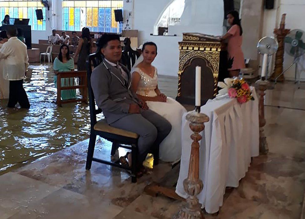 Bride Jobel Delos Angeles and her groom during their wedding in a flooded church in Hagonoy town