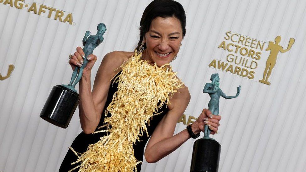 Michelle Yeoh poses with two SAG statuettes