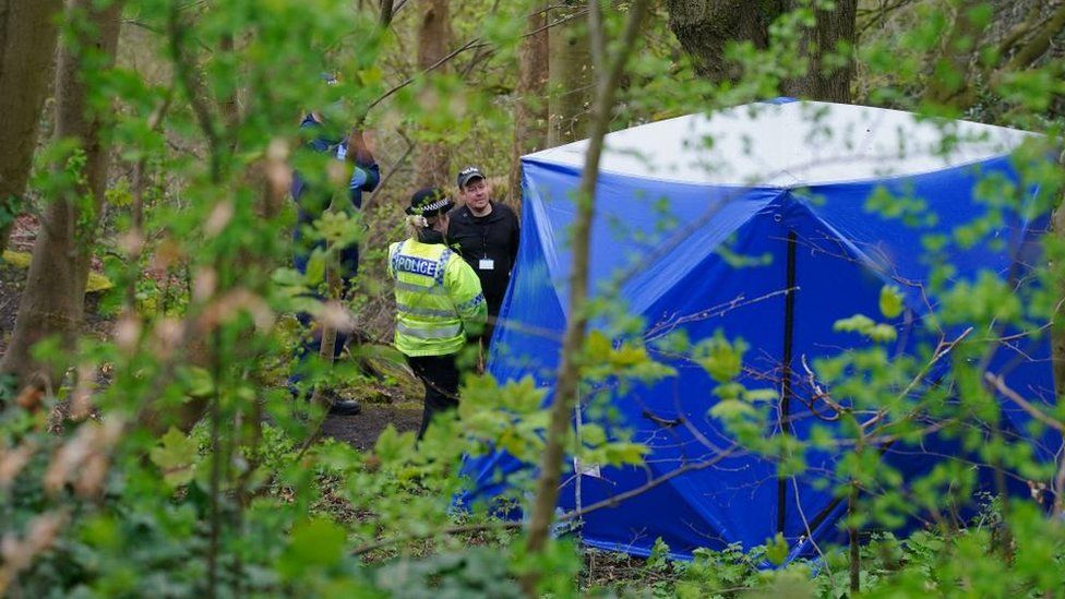 Police officers by a forensic tent at Kersal Dale woodland in Salford