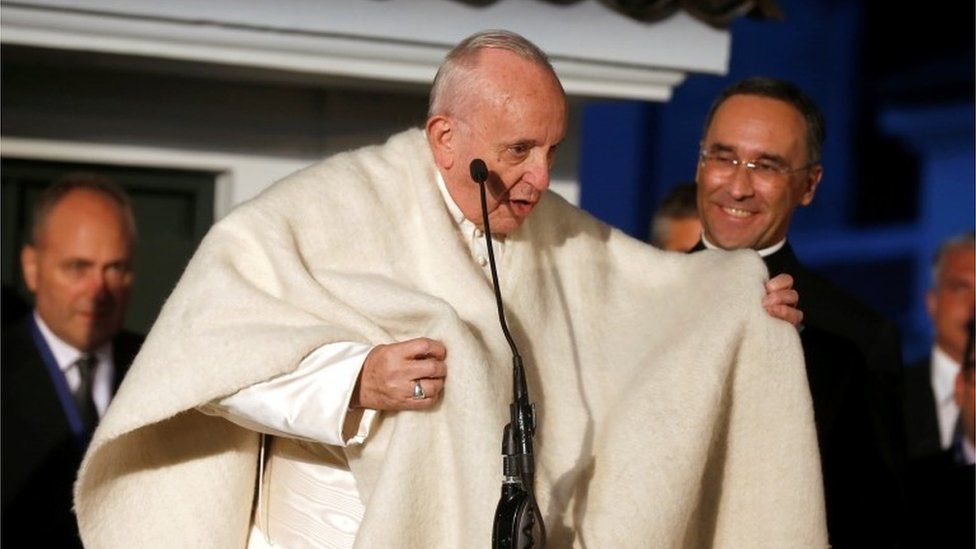 Pope Francis greets the faithful at the Apostolic Nunciature to Colombia in Bogota wearing a ruana.