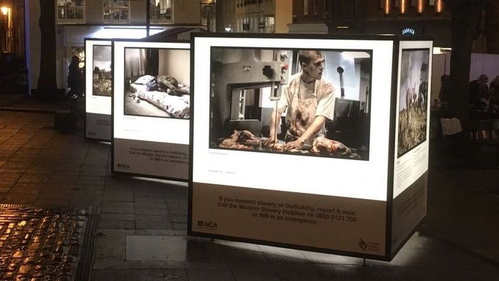 Photographs that depict modern slavery mounted on a cube