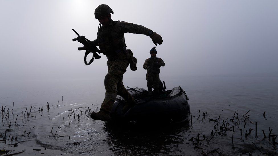 A Ukrainian serviceman jumps out of a boat on the shore of the Dnipro river at the frontline near Kherson, Ukraine, Sunday Oct. 15, 2023.