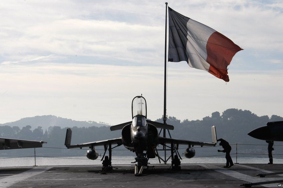 A French sailor checks a Super-Etendard jet on the deck of France's nuclear-powered aircraft carrier Charles de Gaulle in Toulon, 18 November