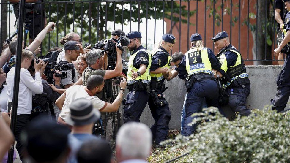 Police intervene as people react to a burning of a copy of the Quran in Stockholm on Wednesday