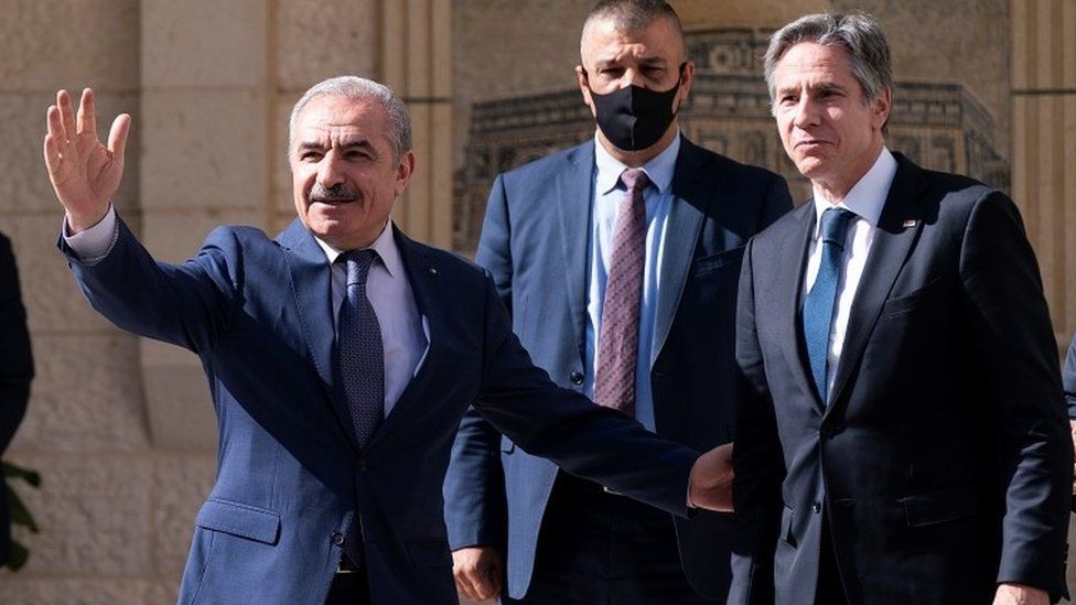 Palestinian Prime Minister Mohammad Shtayyeh waves as he greets Antony Blinken