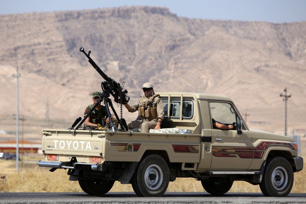 Iraqi Kurdish Peshmerga fighters drive a truck with a machine gun mounted on the back as they head to the Mosul dam on the Tigris river that they recaptured from Islamic State jihadists on August 17, 2014