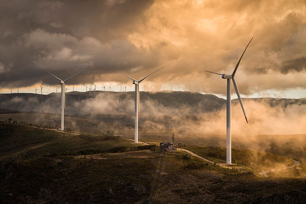 Wind turbines next to a misty mountainous area in Portugal