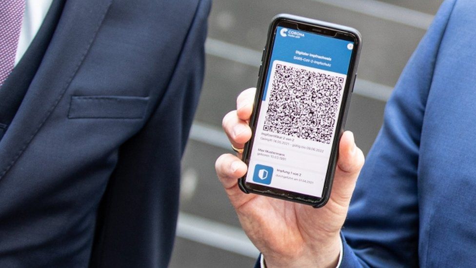 A man hols a mobile phone displaying an EU Digital Covid Certificate