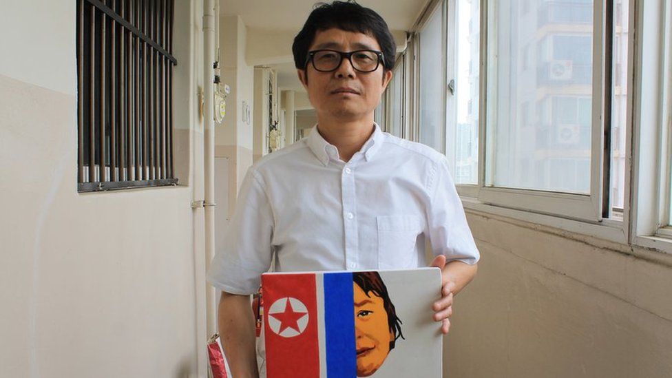 Song Byeok holds up one of his North Korean propaganda pieces