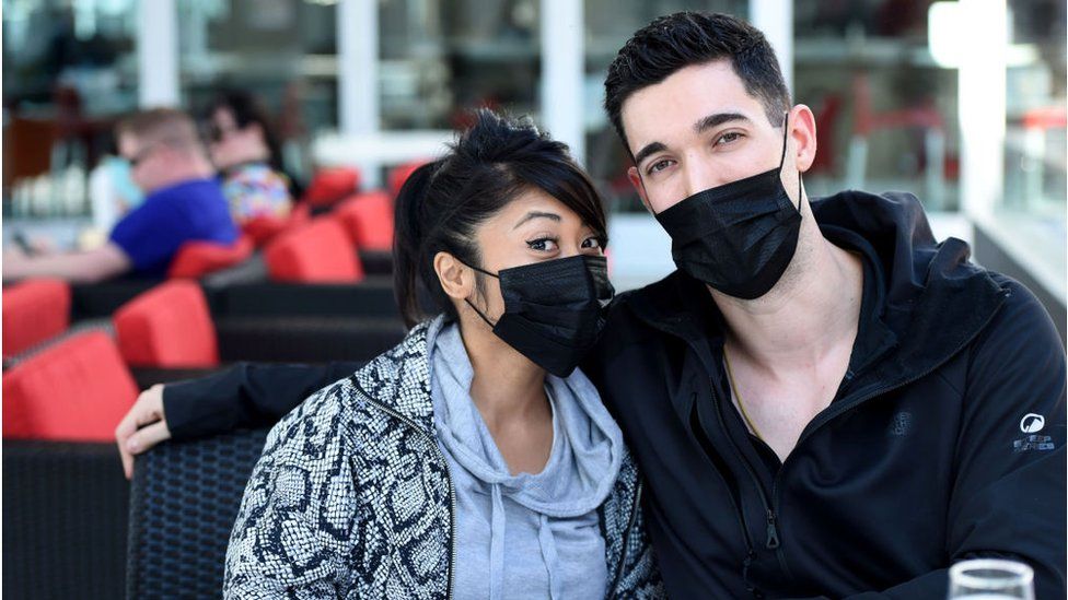 A couple prepares for air travel with masks, hand sanitiser and wipes