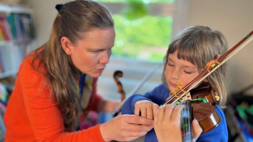 Maria Dobing instructing pupil Penelope on the violin