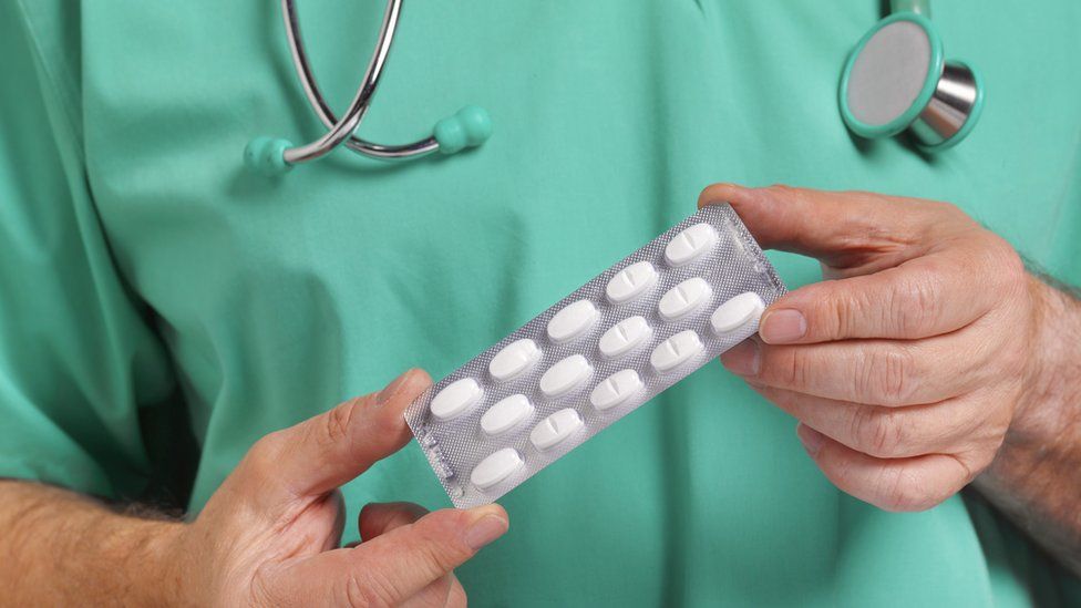 doctor holding a pack of pills