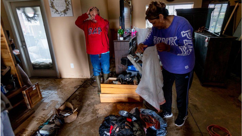 Californians cleaning their flooded home