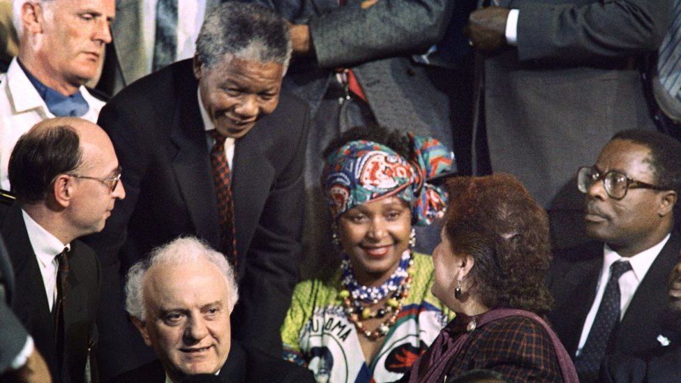 Nelson Mandela and Winnie Mandela (C)speak to Nanuli Shevardnadze (R) seated next to her husband Eduard Shevardnadze (FL), the former Soviet Minister of Foreign Affairs, during the Namibian Independence ceremony in 1990