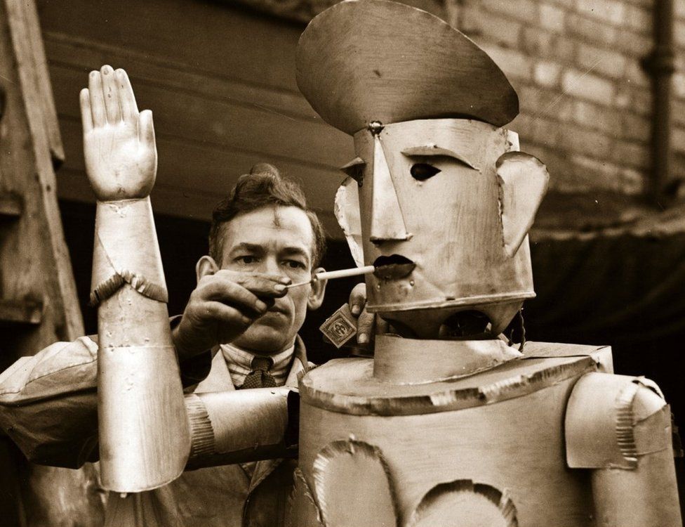 15th January 1939: Mr Charles Lawson, an electrical engineer of Kettering lights his robot's cigarette