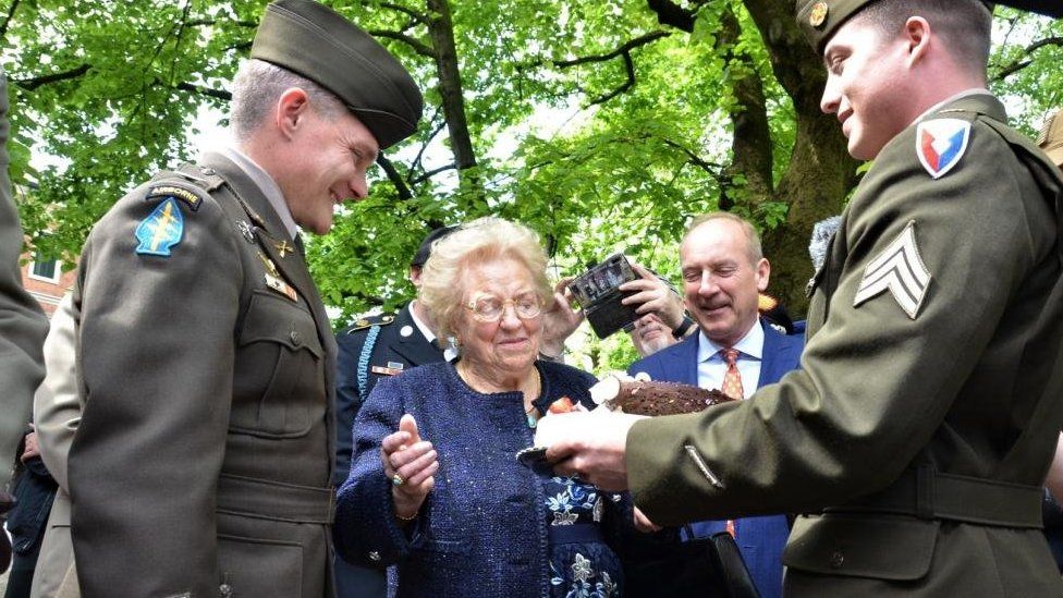 Sgt Wallis (right) and Col Gomlak (left) present the cake to Meri Mion