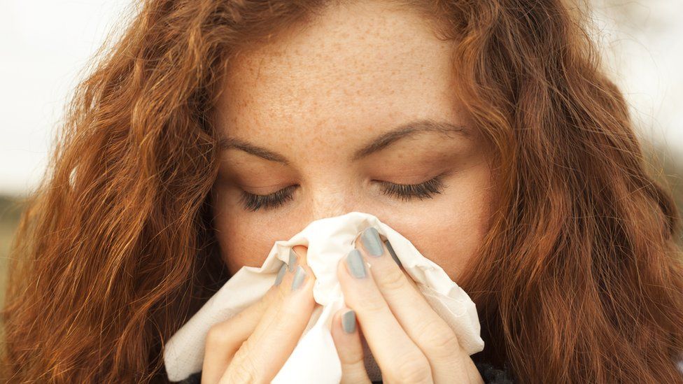 Woman blowing her nose