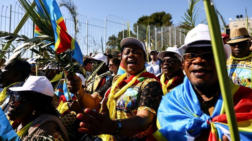 Christian worshippers carry the national flag of the Democratic Republic of Congo as they attend a Palm Sunday procession on the Mount of Olives in Jerusalem April 2, 2023
