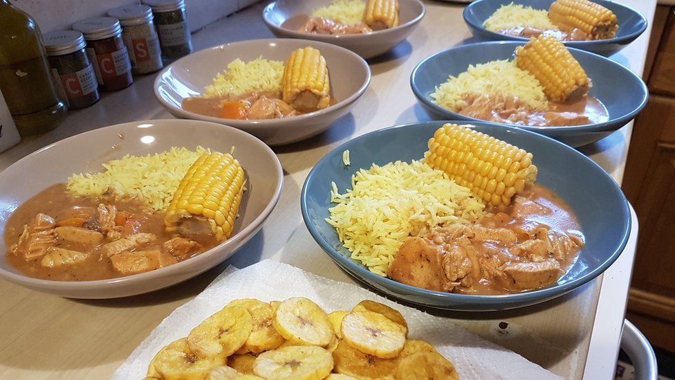 Butter chicken with yellow rice, corn and fried plantains