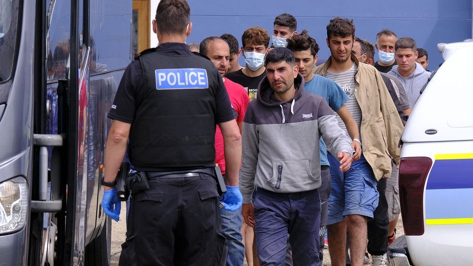Migrants board a coach