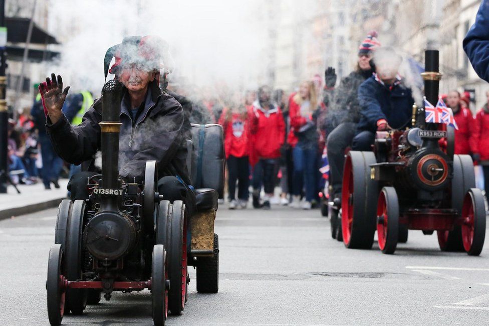 Performers are seen on ancient vehicles during London New Year's Day parade