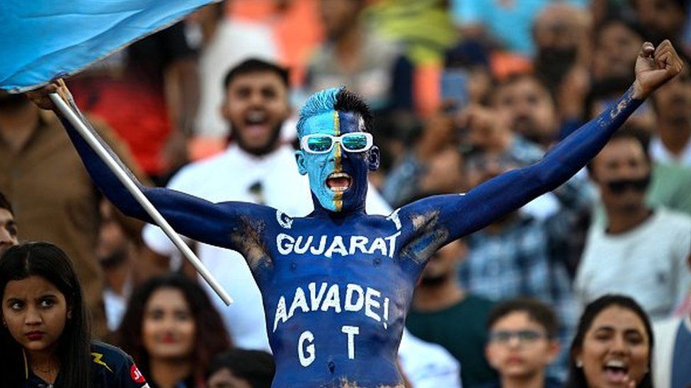 A fan cheers for Gujarat Titans' team while watching the Indian Premier League (IPL) Twenty20 cricket match between Gujarat Titans and Sunrisers Hyderabad at the Narendra Modi Stadium in Ahmedabad on March 31, 2024.
