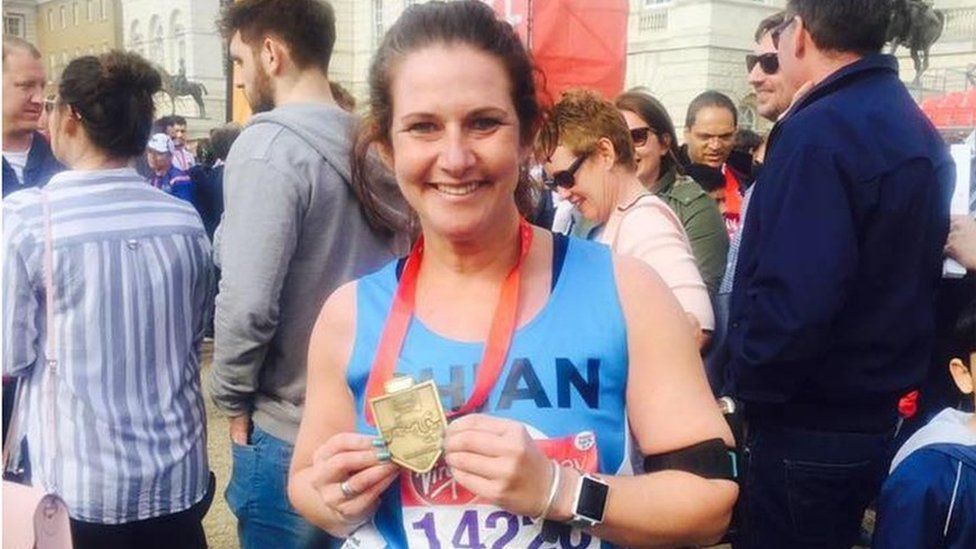 Rhian after running the marathon holding her medal