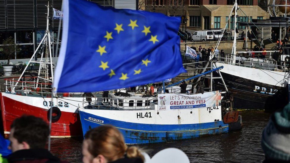 Anti-Brexit protestors fly an EU flag in front of a pro-Brexit campaign from fishermen in Newcastle.