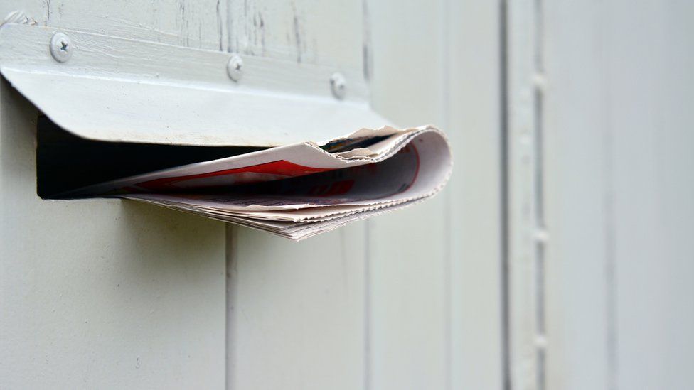 A letter sticking out of a letter box