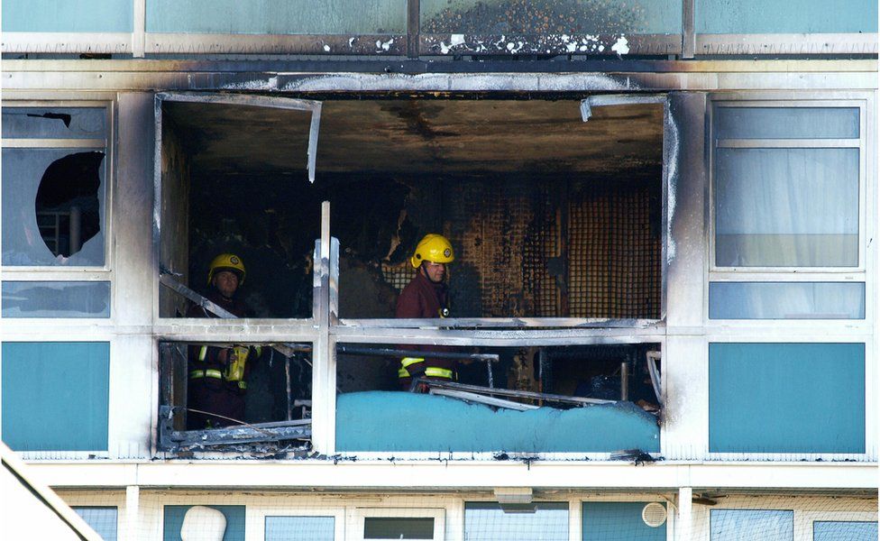 Two firemen check one of the burnt-out flats at Lakanal House