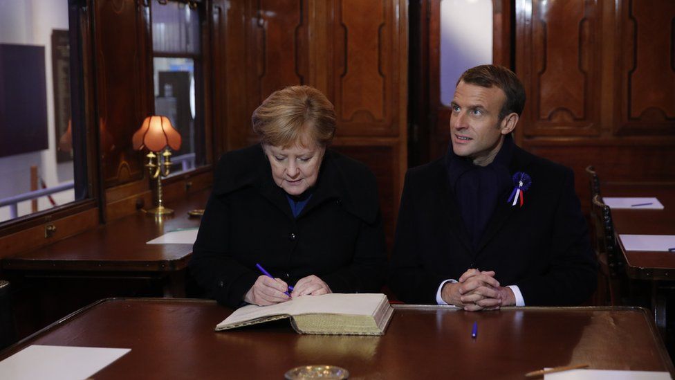 Angela Merkel and Emmanuel Macron sign book of remembrance in the replica railway carriage